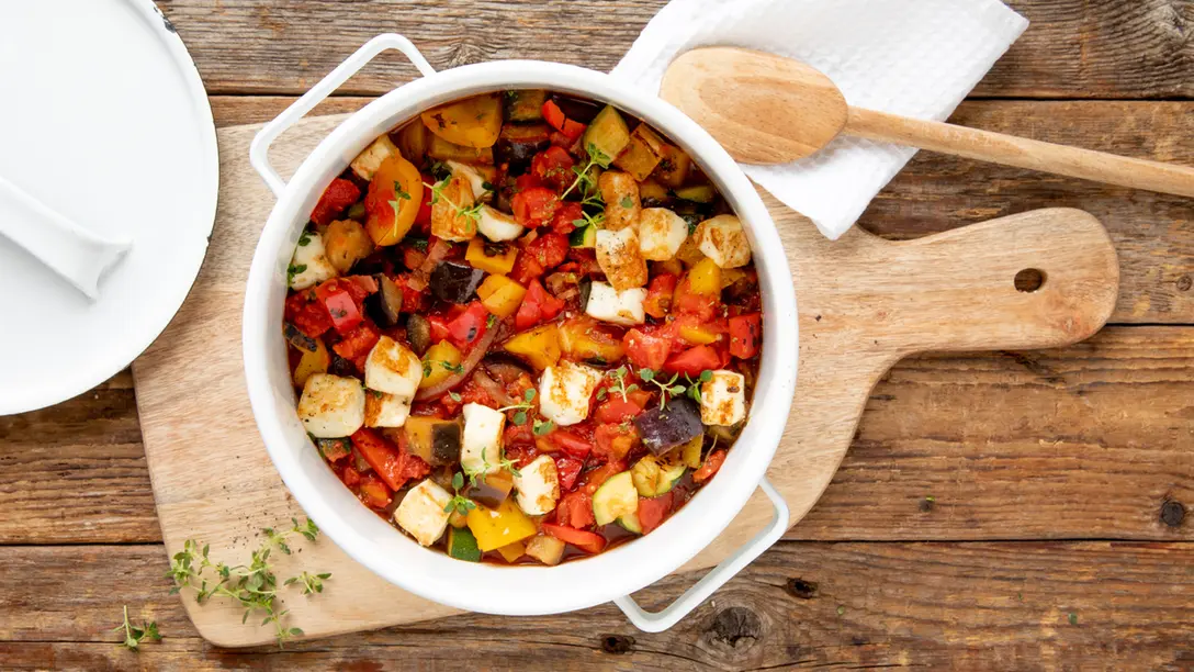 Ratatouille-Eintopf mit Aubergine, Paprika, Zucchini, Tomaten und gebratenem Halloumi in einer Schüssel